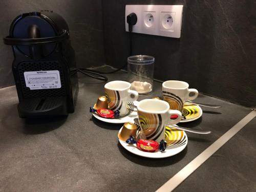 a table with three coffee cups and a microwave at Appartement Cosy Chelles in Chelles