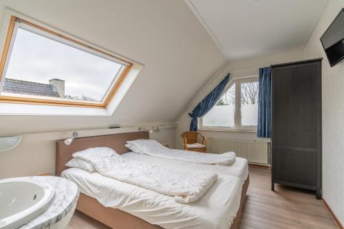 - 2 lits dans une chambre avec lavabo et fenêtre dans l'établissement Villapark Kamperfoelie 43, à De Koog