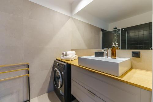 y baño con lavabo y lavadora. en Apartament SEAGRASS SurfingBird Dźwirzyno en Dźwirzyno