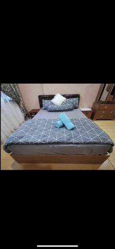 łóżko z 2 poduszkami i niebieskim kocem w obiekcie A Spacious 3BR 2storey House Taman Kosas Ampang w mieście Ampang
