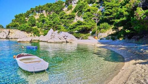 a boat in the water next to a beach at VILA MARIJA in Mimice
