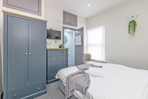a bedroom with a bed and a blue cabinet at 3 Bedroom Holiday House in Liverpool
