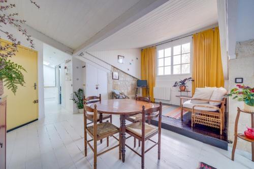 un salon avec une table et des chaises en bois dans l'établissement Le Cosy - Appartement trois chambres centre Bordeaux, à Bordeaux