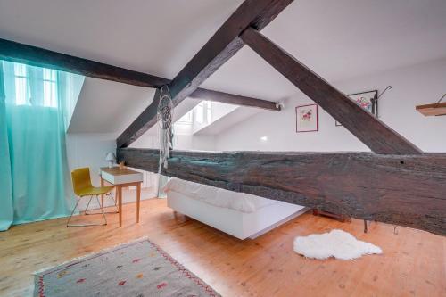 - une chambre mansardée avec une grande poutres en bois dans l'établissement Le Cosy - Appartement trois chambres centre Bordeaux, à Bordeaux