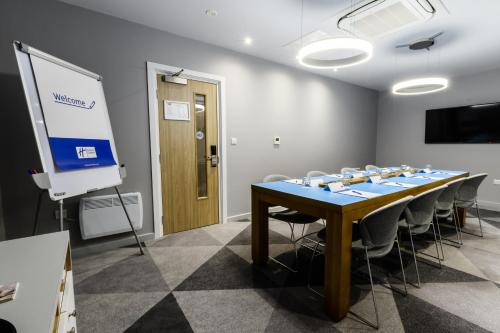 a conference room with a table and chairs and a screen at Holiday Inn Express - Wigan by IHG in Wigan
