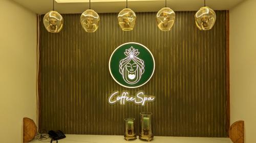 a table with glasses and a sign on a wall at Mayur Belgaum Presidency Hotel & Spa in Belgaum