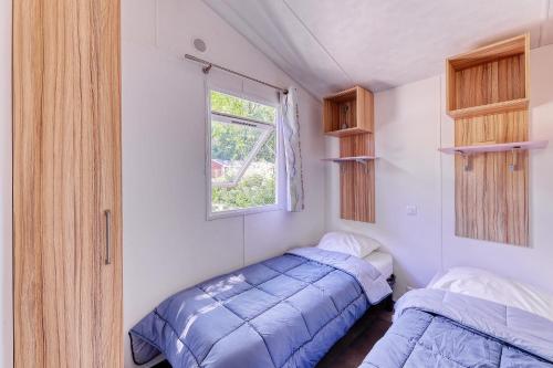 ナントにあるNantes Camping Le Petit Portの小さなベッドルーム(ベッド2台、窓付)