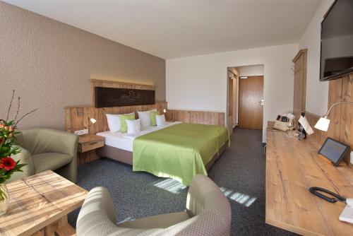 a hotel room with a bed and a table and chairs at Hotel Tyrol - Oberstaufen PLUS Partner in Oberstaufen