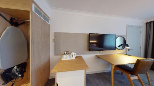 a hotel room with a desk and a mirror at Holiday Inn Brentwood by IHG in Brentwood