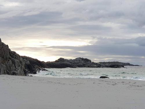 a beach with rocks in the water and the ocean at 6 person holiday home in skudeneshavn-By Traum in Skudeneshavn