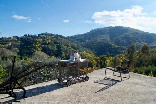 a table and two chairs on a balcony with a mountain at Amoureux du calme et de la nature in Tanneron