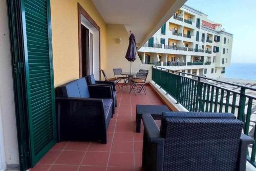 a balcony with chairs and tables and a view of the ocean at SeaBreezeBonimar in Funchal