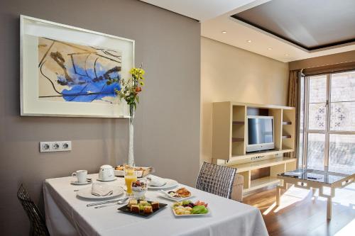 una sala da pranzo con tavolo e cibo di Nexus Valladolid Suites & Hotel a Valladolid