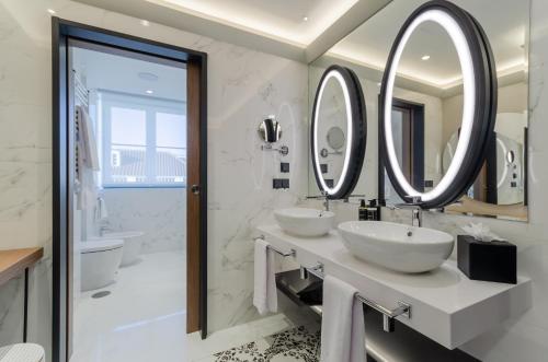 une salle de bain avec deux lavabos et deux miroirs dans l'établissement Eurostars Lisboa Baixa, à Lisbonne