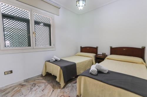 een kamer met 2 bedden en een raam bij 073 - Puerto Varadero 001 - comfortHOLIDAYS in Santa Pola