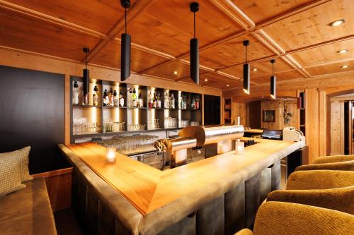 a bar with a wooden counter and chairs at Hotel Landgasthof Gappen in Kramsach
