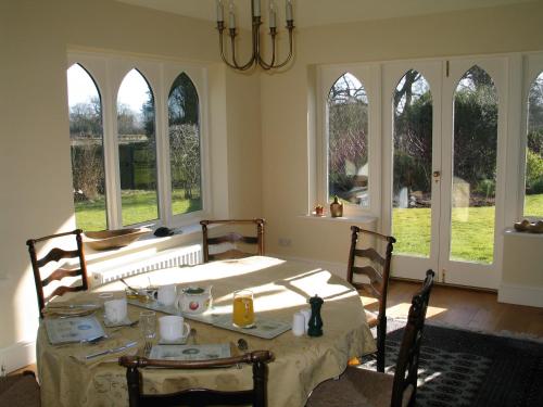 a dining room with a table and chairs and windows at High Rigg B&B in Helmsley