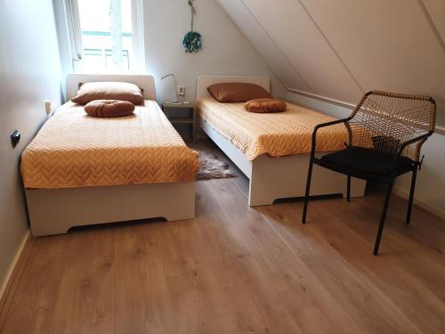 Wilp的住宿－Bij de oude dijk，一间卧室配有两张床和椅子
