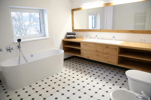 ein Badezimmer mit einer Badewanne, einem Waschbecken und einem Spiegel in der Unterkunft Maribor Luxury Country House Volicina 5* 