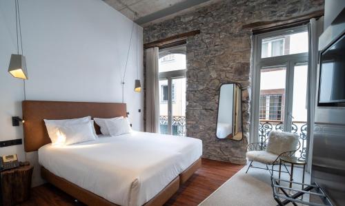 a bedroom with a bed and a balcony at Hotel Cajú in Funchal