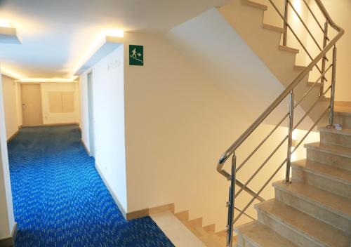 a hallway with stairs and a blue carpet at Washington Plaza in Barranquilla