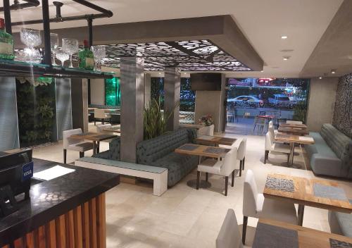 um restaurante com mesas e sofás e mesas e cadeiras em Washington Plaza em Barranquilla