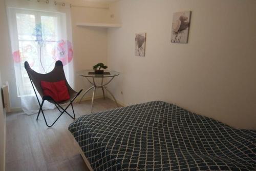 Un dormitorio con una cama, una mesa y una silla. en Zoo Zen 6 pers, au coeur de St Aignan, en Saint-Aignan
