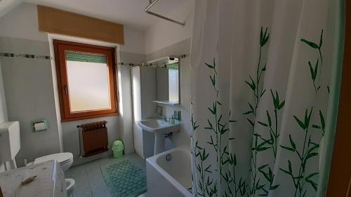 Un baño con lavabo e inodoro y cortina de ducha. en Chateau et Soleil, en Challand Saint Victor