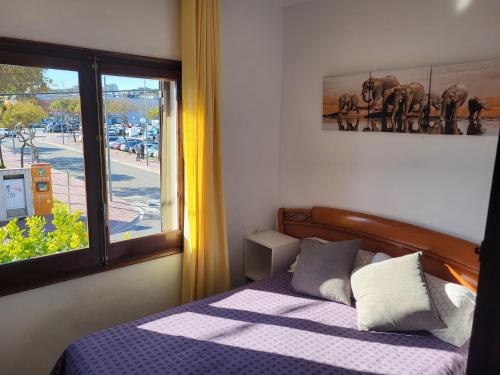 a bedroom with a bed with a view of a street at Can Kuqueta, Platja d'Aro in Platja  d'Aro