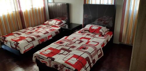 two beds sitting next to each other in a bedroom at J & I Homestay 2 Person with shared bathroom in Sibu