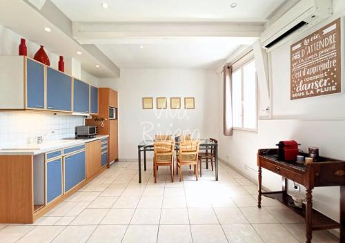une cuisine avec des armoires bleues et une table et des chaises dans l'établissement Viva Riviera Central 1 Bedroom Place Gambetta, à Cannes