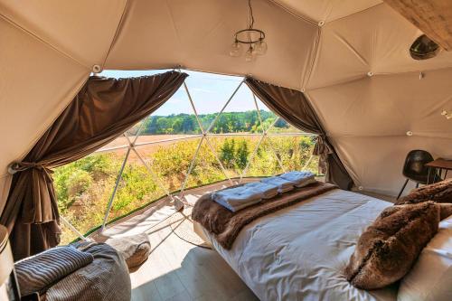 a bedroom in a tent with a large window at Finest Retreats - Scotney Luxury Dome in Hoath