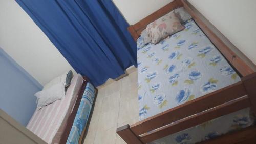 Habitación pequeña con cama y cortina azul en Casa pre-fabricada en Villa María