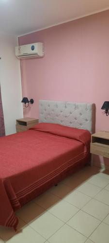 1 dormitorio con cama roja y manta roja en Casa pre-fabricada en Villa María