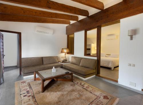 ein Wohnzimmer mit einem Sofa und einem Bett in der Unterkunft Hotel Kabila in Mʼdik