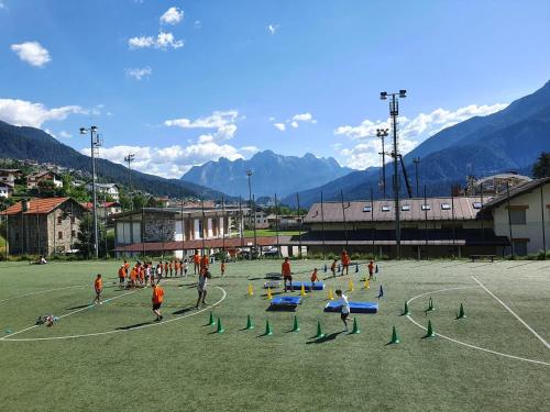 a group of people playing soccer on a soccer field at Lunga Via Delle Dolomiti in Calalzo