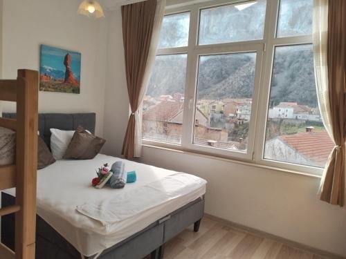 ein Schlafzimmer mit einem Bett und einem großen Fenster in der Unterkunft Guesthouse Sanja - Apartments 212 in Mostar