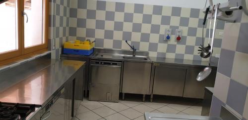 a small kitchen with a sink and a stove at Lunga Via Delle Dolomiti in Calalzo