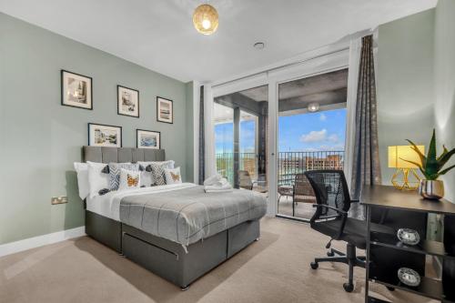 Schlafzimmer mit einem Bett, einem Schreibtisch und einem Fenster in der Unterkunft Queen Elizabeth Olympic Park Apartment in London