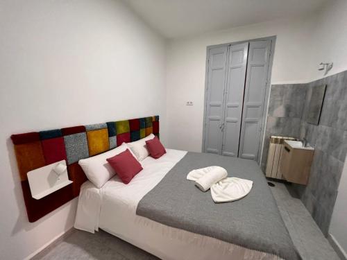 1 dormitorio con 1 cama grande con almohadas rojas en CH Barco, en Madrid