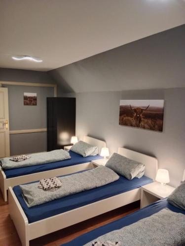 a bedroom with two beds and a painting on the wall at Flensburg Zentrum 10 VH 2OG R in Flensburg