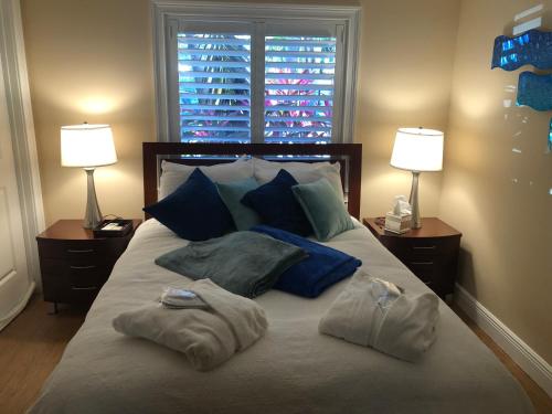 a bed with two pillows on it with two lamps at Private bedroom & den suite with shared pool & tropical garden in Fort Lauderdale