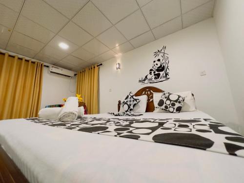 ein Schlafzimmer mit einem großen Bett mit schwarzen und weißen Kissen in der Unterkunft Sachi's place in Tangalle
