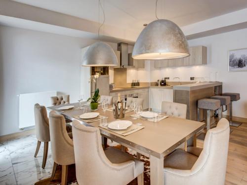 une cuisine et une salle à manger avec une table et des chaises dans l'établissement Spacieux appartement 4 pièces au centre de Courchevel avec accès pistes et parking - FR-1-562-34, à Courchevel