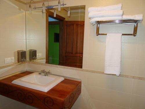 La salle de bains est pourvue d'un lavabo, d'un miroir et de serviettes. dans l'établissement El soportal, à Barbadillo del Pez