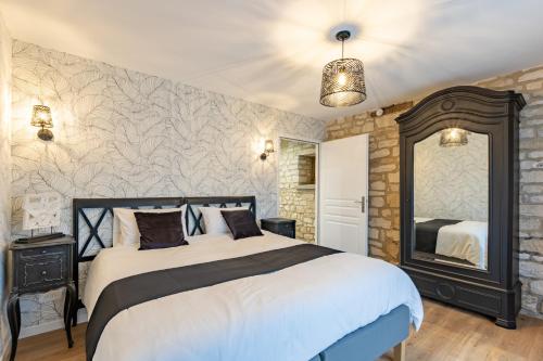 a bedroom with a large bed and a mirror at Gite La Petite Ferme in Clermont-les-Fermes