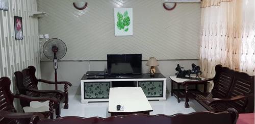 a living room with chairs and a table and a tv at J & I Homestay B 3 Person with shared bathroom in Sibu