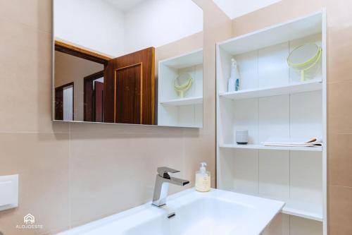 a bathroom with a sink and a mirror at Apartamento Miramar - Piscina e BBQ in Santa Cruz