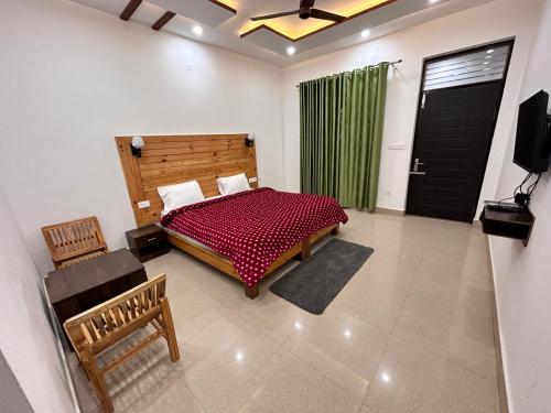 um quarto com uma cama, uma televisão e uma janela em HOTEL HIMALAYAN FOXHOLE em Chakrāta