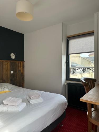 a bedroom with a bed and a window with towels at Papagayo in Saint-Aubin-sur-Mer